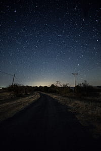 asphalt road under starry night during nighttime thumbnail