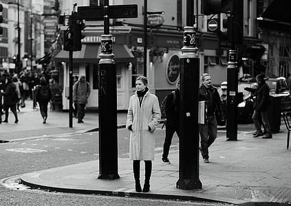woman standing between two posts in grayscale photography thumbnail
