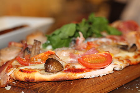 sliced pizza on brown wooden board thumbnail