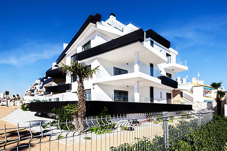 white and black concrete house with tree beside thumbnail