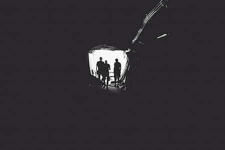 silhoutte of men on entry of cave thumbnail
