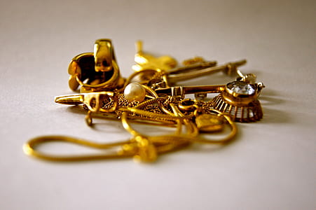 gold-colored accessories on beige top thumbnail