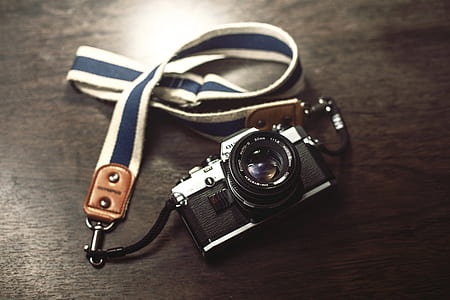black and gray bridge camera with sling on top of board thumbnail