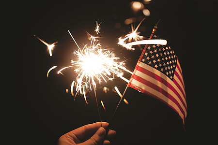 person holding lighted sparkler and USA flaglet thumbnail