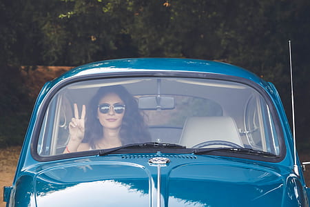 woman inside passenger seat of Volkswagen Beetle coupe thumbnail