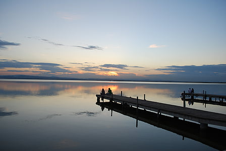 two person sitting on water dock thumbnail