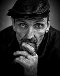grayscale photo of man with leather flat cap thumbnail