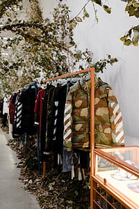 clothes hanging on clothes rack beside white wall thumbnail
