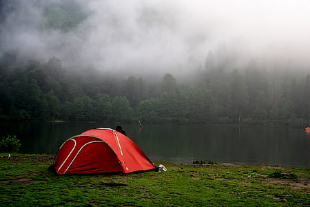 red dome tent placed near lake thumbnail