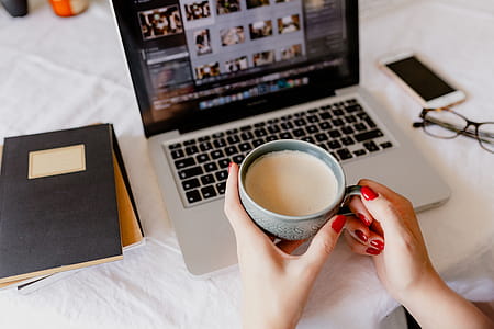 A woman works at a desk with a laptop and a cup of coffee thumbnail