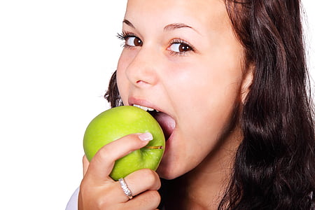 woman with silver-colored ring holding green apple thumbnail