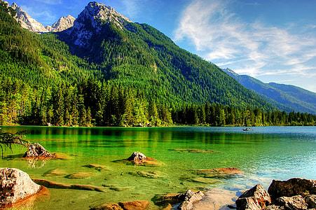 green mountain beside body of water during daytime thumbnail