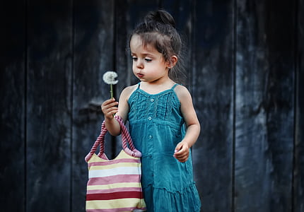 girl wearing green dress holding dandelion thumbnail