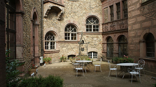two white table set between brown buildings thumbnail