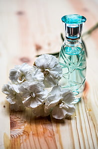 blue perfume bottle on brown wooden surface thumbnail