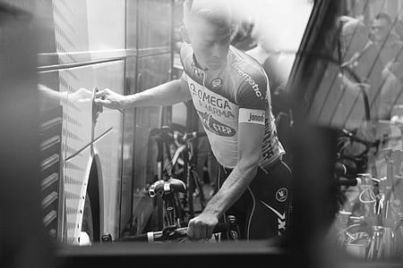 grayscale photograph of man moving bike in stairway thumbnail