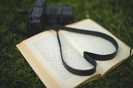 camera beside book on grass thumbnail