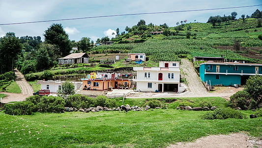 landscape photography of houses below a hill thumbnail