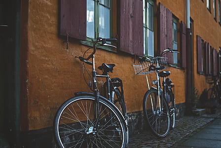 two black commuter bikes park beside wall during daytimes thumbnail