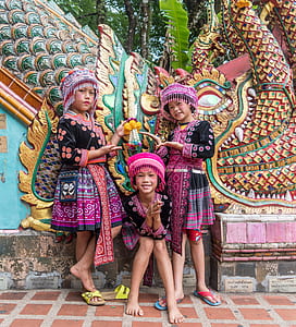 three children standing in front of wall thumbnail