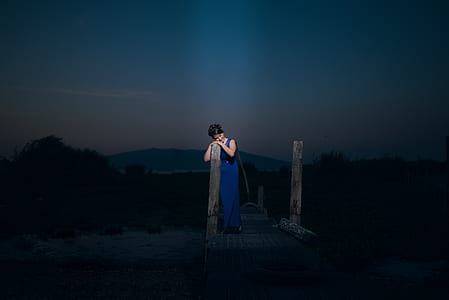 woman leaning on wood post thumbnail