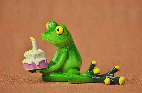 selective focus photography of green frog holding cake figurine thumbnail