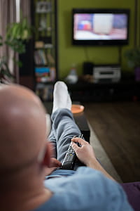 man watching television using remote control thumbnail