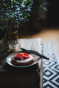 selective focus photo of pancake with strawberry toppings on plate with knife and fork thumbnail