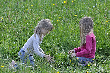 two girl seating on field of grass thumbnail
