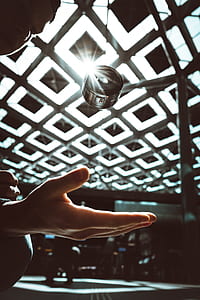person throwing round black camera lens upward thumbnail