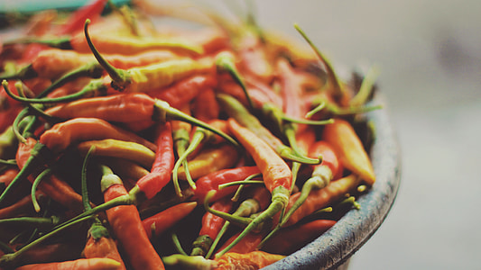 shallow photography of red and green chili lot on black bowl thumbnail