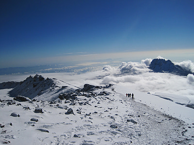 four people walking near snow field thumbnail