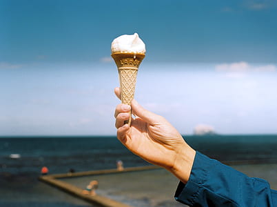person holding ice cream cone outdoors thumbnail