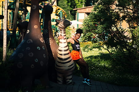 Photo of Woman Sitting on Zebra Statue thumbnail