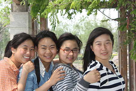 four women smiling in front of camera during daytime thumbnail
