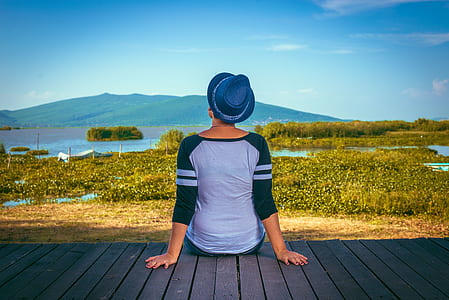 woman wearing raglan shirt and hat sitting on backyard balcony thumbnail
