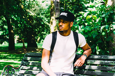 man sitting on bench leaning near tree thumbnail