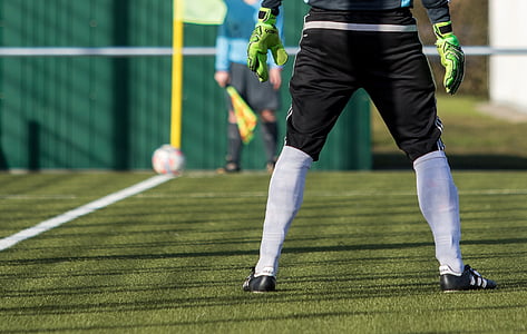 shallow focus photography of soccer player standing on grass field thumbnail