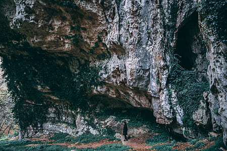 Person Under Black and Gray Cliff thumbnail