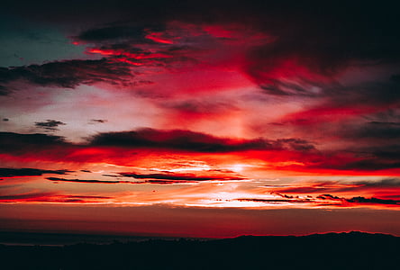 silhouette of mountain under cloudy sky during golden hour thumbnail