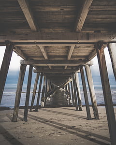 low angle photography of brown sea dock at day time thumbnail