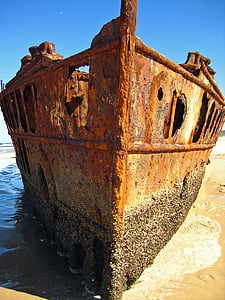 brown rusty ship docked near shore thumbnail