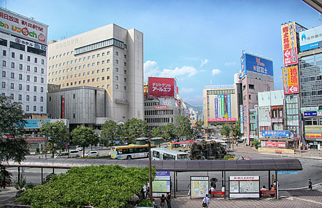 people walking near road and high rise buildings under blue sky thumbnail
