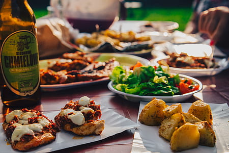 Green Salad on White Plate Near Grilled Potatoes on Brown Table thumbnail