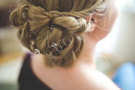 selective focus photography of woman's tied blonde hair wearing black top thumbnail