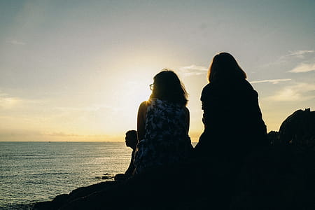Silhouette of Two Women Facing Body of Water thumbnail