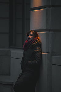 woman leaning on wall during nighttime thumbnail
