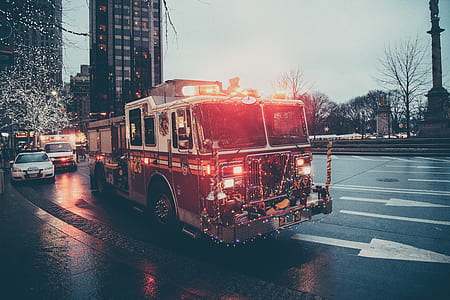 emergency vehicles on road with turned on beacon lights under gray skies thumbnail