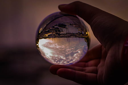 Selective Focus Photography of Person Holding Glass Ball thumbnail