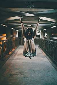 selective focus photo of woman hanging on ceiling bar thumbnail